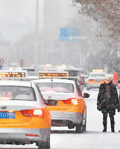 2018年12月7日,新疆喀什迎来降雪,出租车司机载上等候乘车的人送往