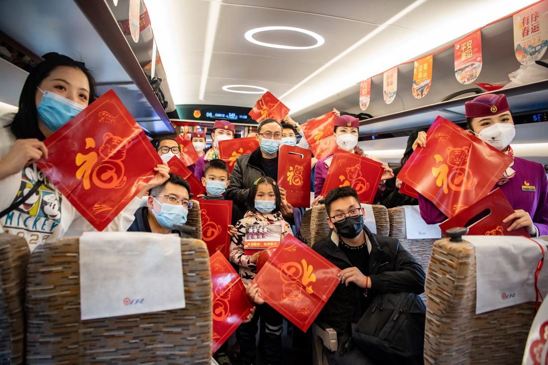 1月17日，旅客在G8612次“共青团号”列车上展示小礼品。