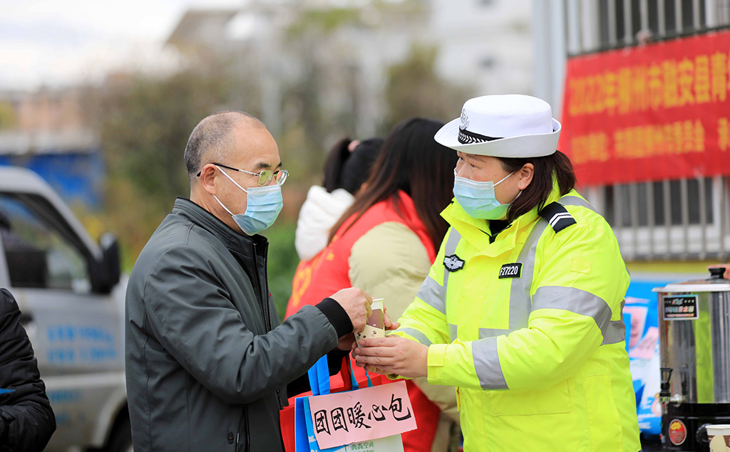 1月17日，在209国道广西柳州市融安县段“春运爱心驿站”，交通辅警为司乘人员送姜糖茶。