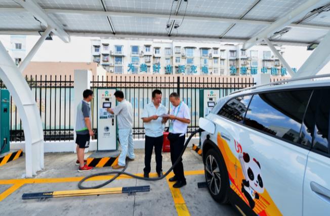 7月22日，国网四川电动汽车服务公司员工为客户提供充电服务帮助。陈翔供图